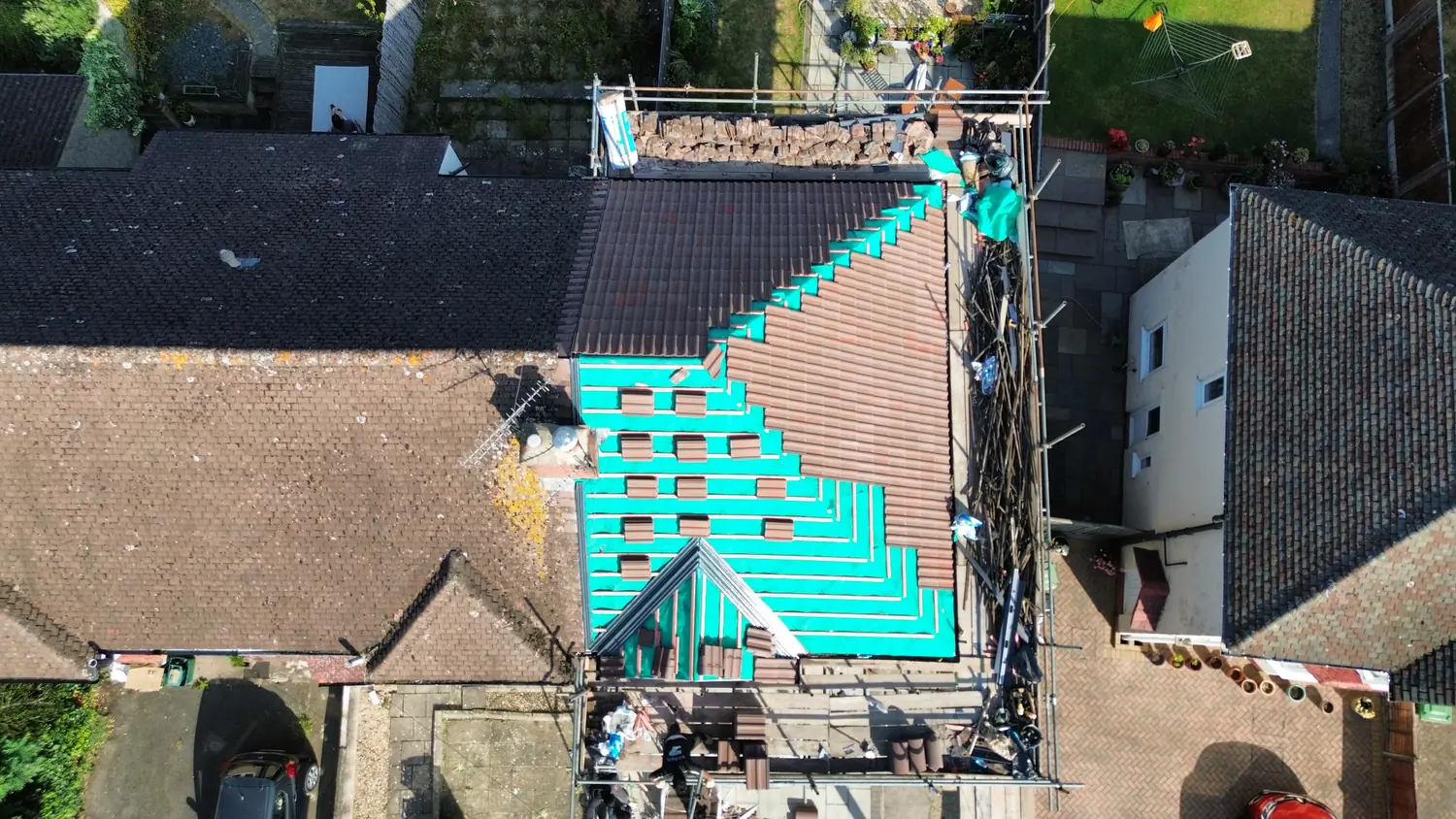 Drone photograph of a Bristol re-roof mid-job, showing the breathable membrane and new tiles being laid out in courses